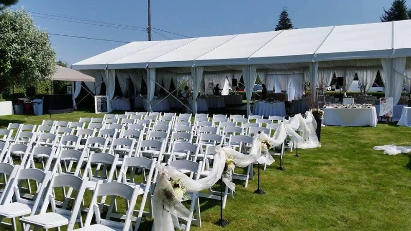 Apollo Event Rentals team setting up a wedding tent and reception furniture at a Kelowna venue