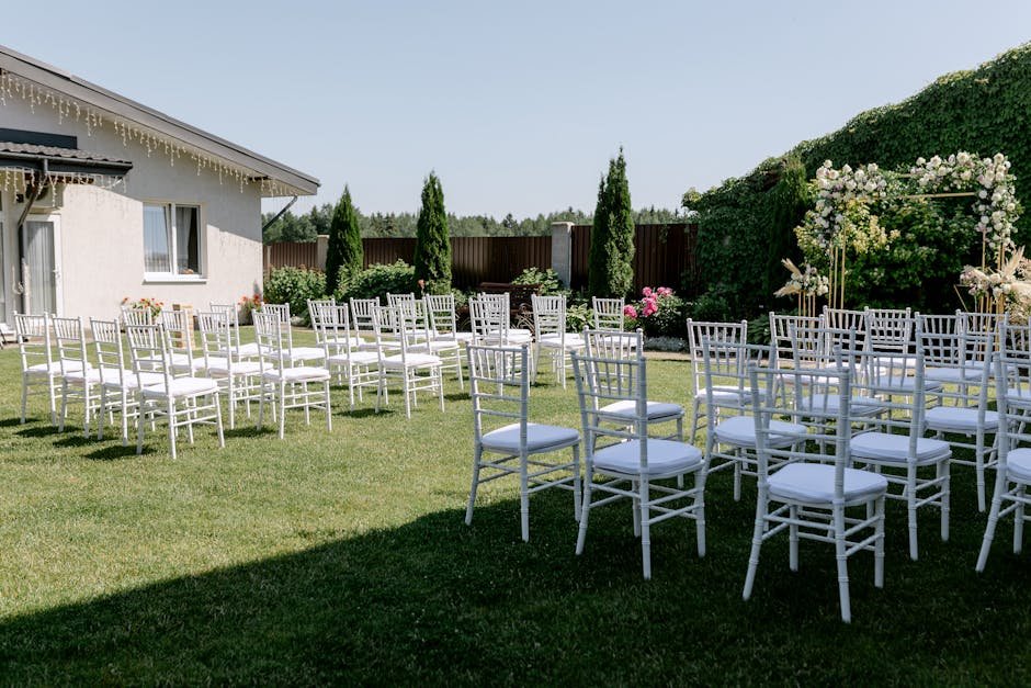 Elegant backyard wedding reception setup with white marquee tent, chiavari chairs, and string lights in the Okanagan