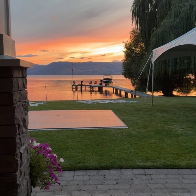 Outdoor dance floor rental setup on grass beside a lake for a BC wedding event