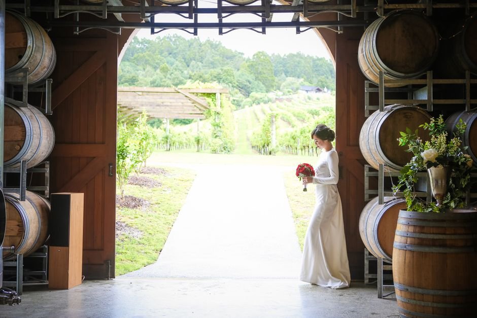 wine barrel rental Okanagan set up as ceremony altar with floral arrangements at vineyard wedding